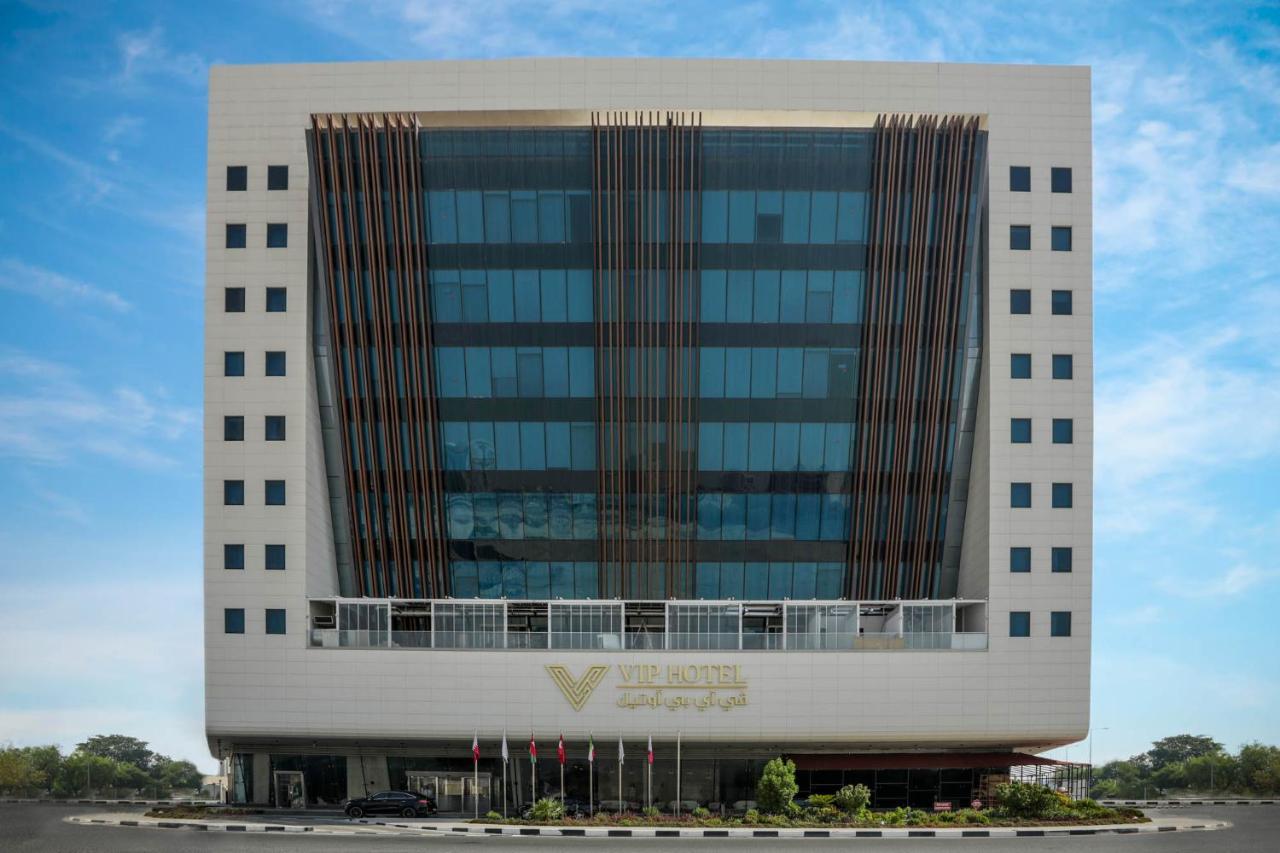 Vip Hotel Doha Qatar Extérieur photo The image shows a modern office building that features a sleek design with a predominantly glass facade. The structure has multiple stories, and the glass windows are framed with decorative elements. The entrance is at the bottom, possibly featuring 